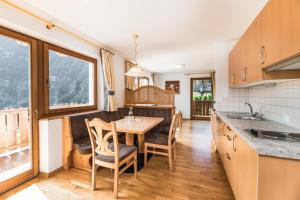 eine Küche und ein Esszimmer mit einem Tisch und Stühlen in der Unterkunft Residence Rumanon in St. Ulrich in Gröden