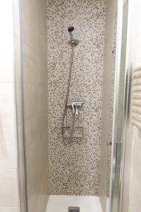 y baño con ducha y pared de azulejos. en Aptos Centro A y B FAMORCAS, en Almodóvar del Río