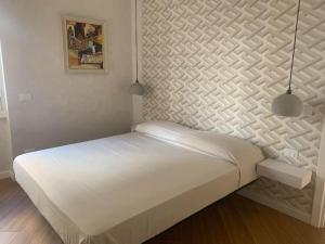 um quarto com uma cama branca e 2 luzes pendentes em L'angolo di Greta em Roma