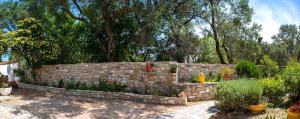 a stone retaining wall in a yard with trees at Country house in Longós