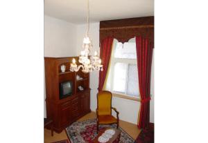 a room with a chair and a window and a chandelier at Excellent Location in Bratislava