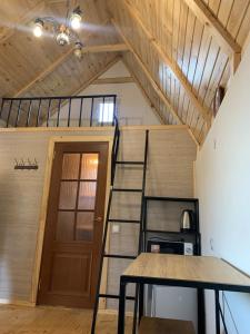 a spiral staircase in a tiny house with a table at Вуличок in Kamianets-Podilskyi
