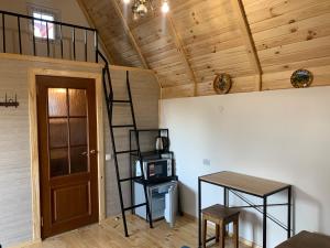 a room with a ladder and a table and a staircase at Вуличок in Kamianets-Podilskyi