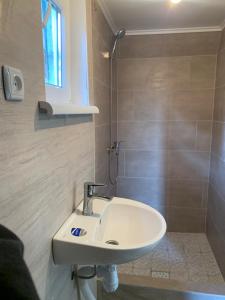 a bathroom with a sink and a shower at Вуличок in Kamianets-Podilskyi