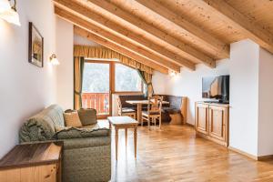 a living room with a couch and a table at Residence Rumanon in Ortisei