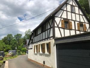 a black and white building with a garage at Ferienhaus Ehrbachklamm in Brodenbach