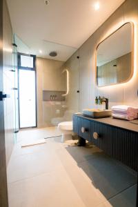 a bathroom with a sink and a toilet and a mirror at Be Mate Medellín in Medellín