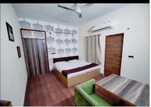 1 dormitorio con 1 cama y 1 sofá verde en Hotel TSR By WB Inn en Agra