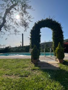 an arch with bushes in a park near a body of water at Agriturismo IL VIAIO in Fiesole