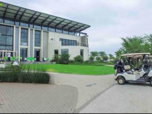 a golf cart parked in front of a building at Cozy Self Catering Apartment with Golf Course Views, Jackal Creek Golf Estate in Roodepoort