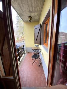 einen Balkon mit einem Tisch und einem Stuhl in einem Zimmer in der Unterkunft Chicca nel cuore dell'Abetone in Abetone