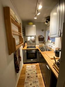 uma pequena cozinha com um fogão e um lavatório em Chicca nel cuore dell'Abetone em Abetone