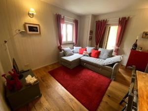 ein Wohnzimmer mit einem Sofa und einem roten Teppich in der Unterkunft Chicca nel cuore dell'Abetone in Abetone
