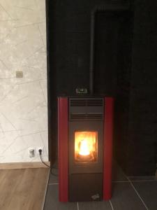 a stove with a fire in it in a room at L’annexe in Lunéville