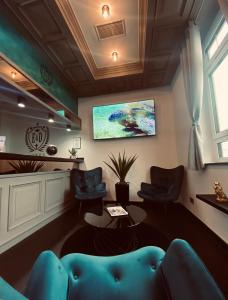 uma sala de espera com um sofá azul e uma televisão em E&D Hotel Rodgau em Rodgau