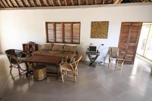 ein Wohnzimmer mit einem Sofa, einem Tisch und Stühlen in der Unterkunft Baobab Beach Villa, Ushongo Beach, Pangani in Ushongo Mabaoni