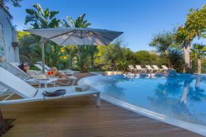 a swimming pool with chairs and an umbrella at Sorrento Dream in Sorrento