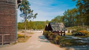 a barn with a pathway next to a building at Penzion Selský dvůr Braňany in Braňany