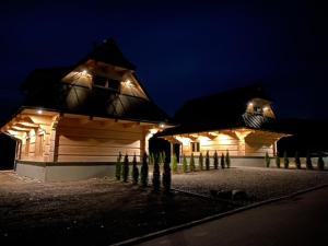 a wooden house with lights on it at night at Na Południe in Białka Tatrzańska