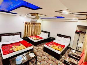 a room with two beds in a room at Jan Luxury Hotel in Quetta