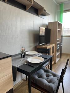 comedor con mesa negra y sillas en Skyway Apartment by LMG, en Sofía