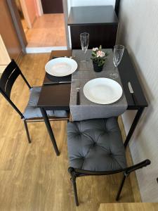 una mesa y sillas con platos y copas de vino en Skyway Apartment by LMG, en Sofía