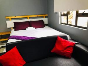 1 dormitorio con 1 cama con almohadas rojas en Ndlovu Palace en Ragbubee