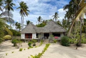 una pequeña casa en la playa con palmeras en Baobab Beach Villa, Ushongo Beach, Pangani, en Ushongo Mabaoni