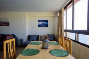 un comedor con una mesa con platos verdes. en Sun&Beach View Apartments, en Benidorm