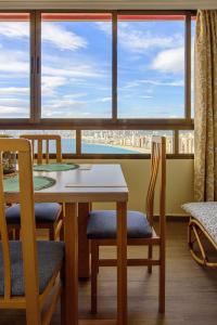ベニドルムにあるSun&Beach View Apartmentsの大きな窓のある客室で、テーブルと椅子が備わります。