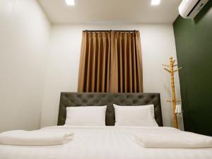 1 dormitorio con 1 cama grande con almohadas blancas en Talaytime Pool Villa en Laem Sing