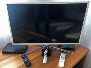 a computer monitor on a desk with two remote controls at Zentral, Ruhig, Sonnig, Modern in Lenzerheide