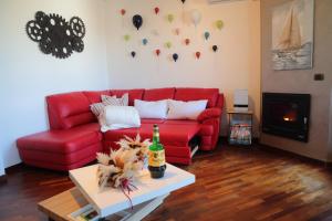 a living room with a red couch and a table at Stanza in Appartamento incantevole con camino Adelfia Bari in Adelfia