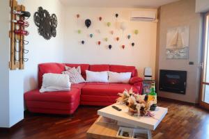 a living room with a red couch and a table at Stanza in Appartamento incantevole con camino Adelfia Bari in Adelfia