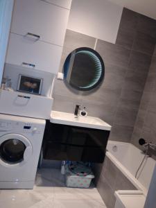 y baño con lavabo y lavadora. en Apartamenty Piastów, en Cracovia