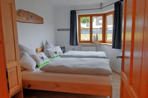 two beds in a room with a window at Ammervital - Apartments in Bad Bayersoien