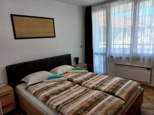 a bed in a bedroom with a large window at APARTMENT TONI / 2BEDROOMS in Varna City