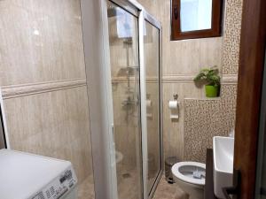 a bathroom with a glass shower and a toilet at APARTMENT TONI / 2BEDROOMS in Varna City
