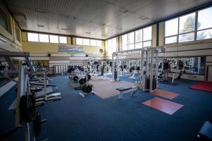 a gym with lots of equipment and people in it at Hotel Sport in Karviná