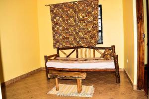 a bed in a room with a curtain and a window at Hillsgate Hotel in Namanga
