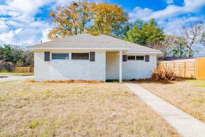 una casa blanca con una valla en un patio en House in Mobile Newly Renovated! Quiet & Centrally Located!, en Mobile