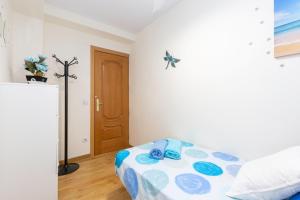 sypialnia z łóżkiem z niebiesko-białym kocem w obiekcie Apartamento Puente de Segovia w Madrycie