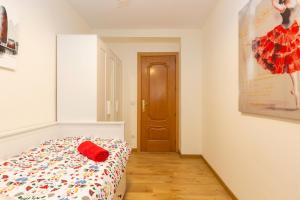 a bedroom with a bed with a red pillow on it at Apartamento Puente de Segovia in Madrid