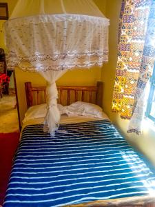 a bedroom with a bed with a canopy and a window at Hillsgate Hotel in Namanga