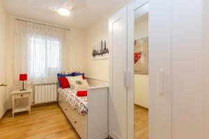 um pequeno quarto com uma cama e uma janela em Apartamento Puente de Segovia em Madri