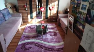 un soggiorno con divano e tappeto viola di Robi kula a Visoko