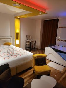 Cette chambre comprend un grand lit et une chaise. dans l'établissement SPA Celyna appartement avec jacuzzi privatif, à Lyon