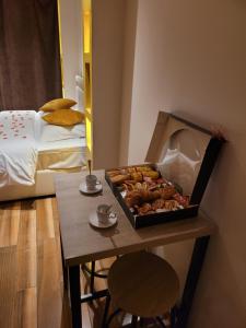 Cette chambre comprend une table et un plateau/bouilloire. dans l'établissement SPA Celyna appartement avec jacuzzi privatif, à Lyon