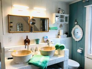 twee wastafels in een badkamer met twee spiegels bij Villa Kunterbunt in Härkingen