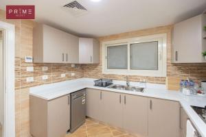 a kitchen with white cabinets and a sink at Prime Select New Giza in Giza